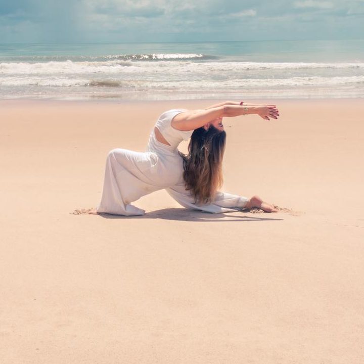 Madu em prática de yoga na praia